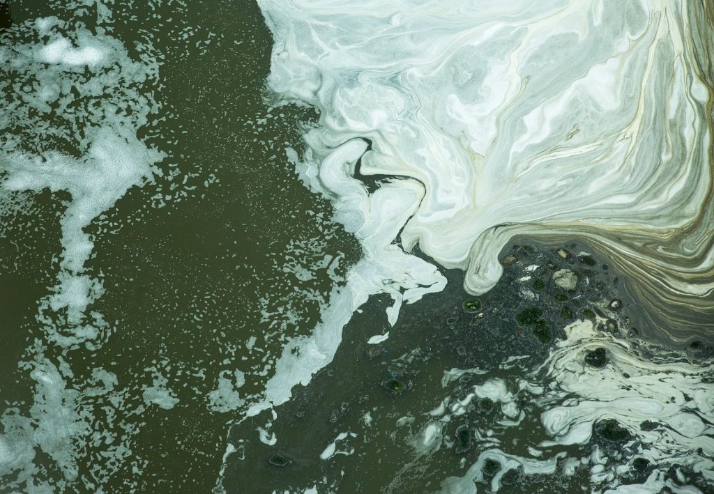 Black water with white bubbles in the waste water treatment pond